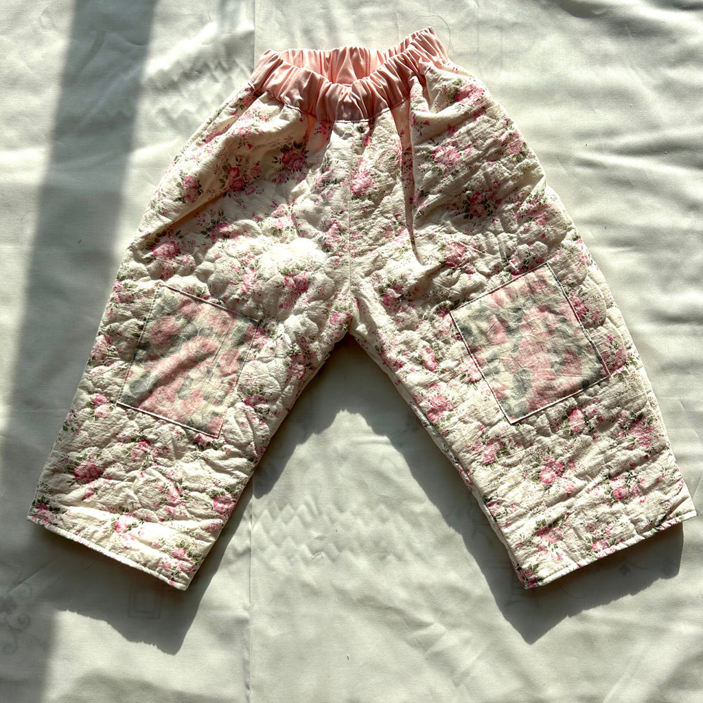 Floral-patterned baby pants on a light fabric background